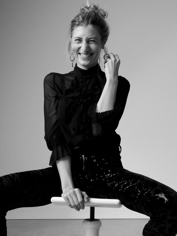 Marta Waydel laughing, seated on a stool
